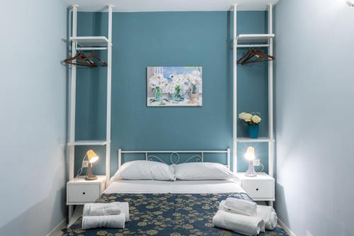 a bedroom with blue walls and a bed with towels at HOSTEL PORTICI in Portici