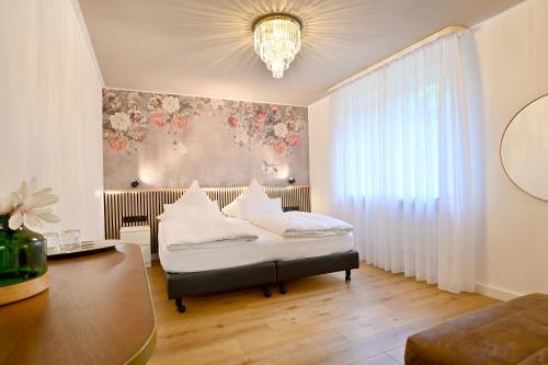 ein Schlafzimmer mit einem Bett und einer Wand mit Blumen in der Unterkunft Hotel Zehnthof in Cochem