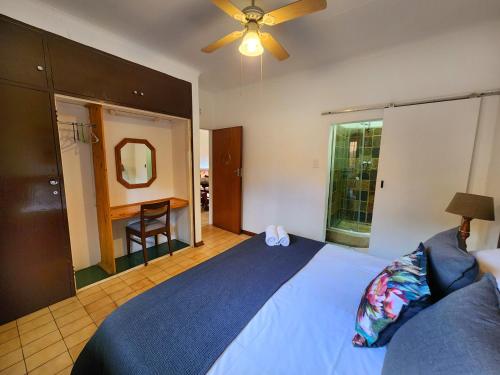 a bedroom with a blue bed and a ceiling fan at Pine Valley in Lanseria