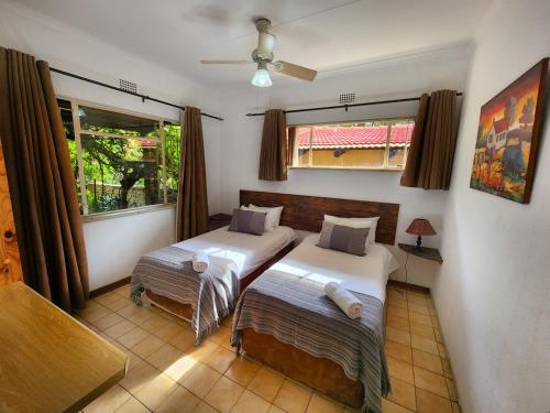 a bedroom with two beds and a window at Pine Valley in Lanseria