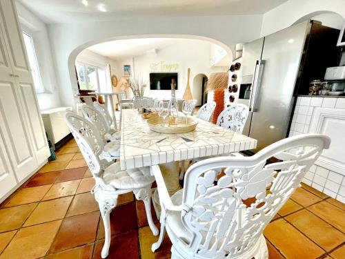 a dining room with a white table and chairs at Villa provençale Golfe St Tropez climatisée piscine chauffée, Spa, billard, Wifi haut débit pro in Gassin