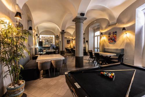 a pool table in a room with tables and chairs at HOSTEL PORTICI in Portici