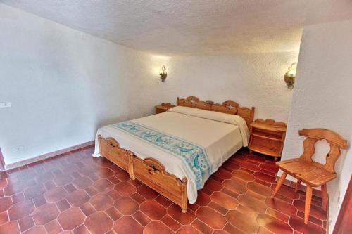 聖特奧多羅的住宿－HOTEL AL FARO spiaggia la Cinta SanTeodoro，一间卧室配有一张床和一把椅子