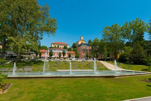a fountain in a park in front of a building at Landhaus Bad Gleichenberg in Bad Gleichenberg