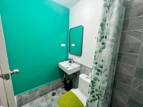 La salle de bains est pourvue d'un lavabo, de toilettes et d'un miroir. dans l'établissement Grand stay at Isla Stays, à Cebu