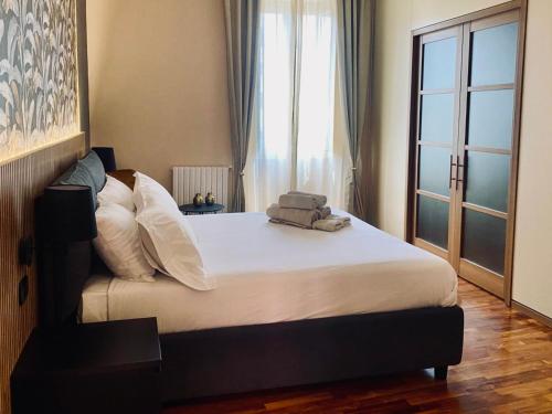 a bedroom with a bed with pillows and a window at La Fontana Luxury Apartment in Nettuno