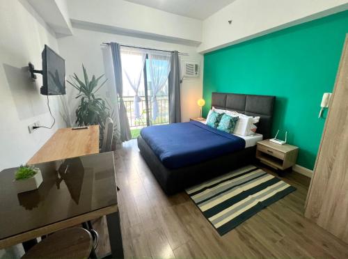 宿霧市的住宿－Grand stay at Isla Stays，一间卧室设有蓝色的床和绿色的墙壁