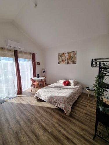 a bedroom with a bed and a table in it at Escapade Beaujolaise - Studio in Taponas