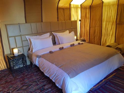 a bedroom with a large bed in a room at Hôtel Camping La Liberté in Merzouga