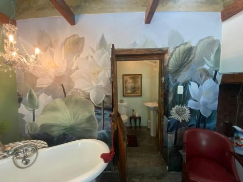 baño con un mural de flores en la pared en The Riverdeck Accommodation and Backpackers, en Knysna