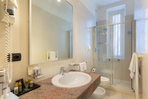 a bathroom with a sink and a toilet and a shower at Grand Hotel Mediterranee in Alassio