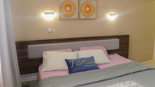 a bedroom with a bed with two pillows on it at Palm Court Apartment in Accra