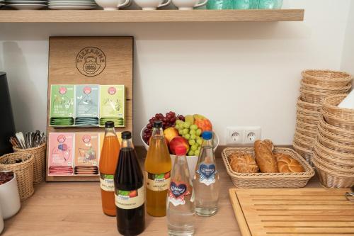 a table with bottles of wine and a basket of fruit at Landhaus Bad Gleichenberg in Bad Gleichenberg