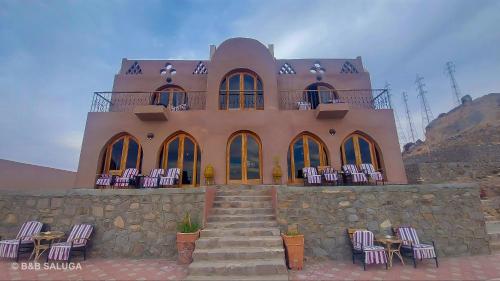 a building with a bunch of chairs in front of it at B&B Saluga Sehel Island Nubian House in Aswan