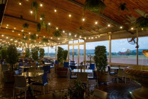 un restaurant avec des tables, des chaises et des lumières dans l'établissement Villa San Giovanni Accommodation, à Pretoria