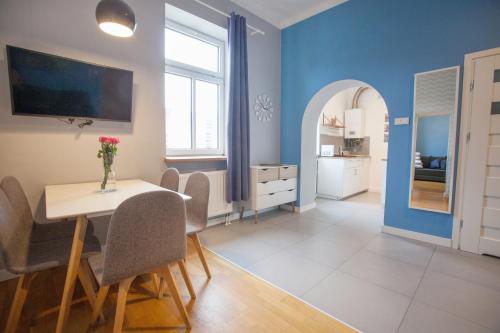 a dining room with blue walls and a table and chairs at Smart Old Town Apartment in Krakow