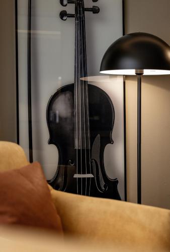 a violin is next to a lamp and a guitar at Vivaldi Hotel in St Julian's