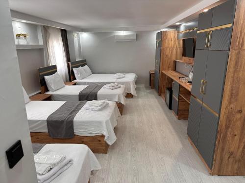 une chambre d'hôtel avec trois lits et une cuisine dans l'établissement Efehan Otel, à Şanlıurfa