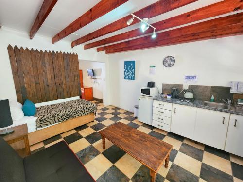 a kitchen with a bed and a table in a room at Pine Valley in Lanseria