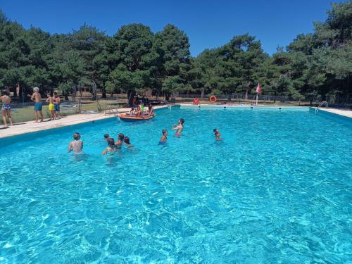 un groupe de personnes dans une grande piscine dans l'établissement Albergue de Condemios de Arriba - Aventurarte, à Condemios de Arriba