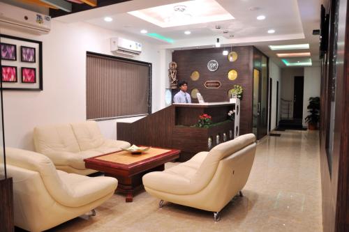 奧蘭加巴德的住宿－Hotel Krishna Inn, Aurangabad，一位在等候室里的人,有椅子和桌子
