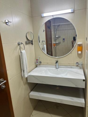 a bathroom with a sink and a mirror at Reem 1 in Ajman 