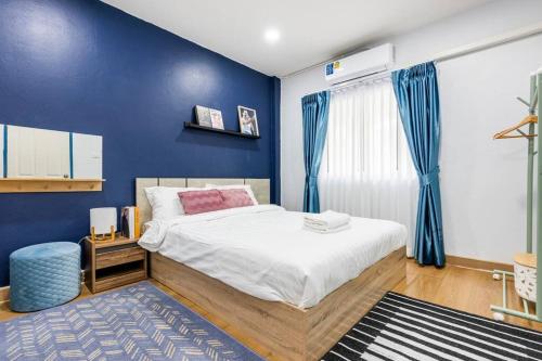 um quarto com uma cama com uma parede azul em RB01 Chatuchak, Netflix, SpeedNet, Bts,mrt, 10Pax em Bangkok