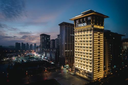 a lit up building in a city at night at voco Xi'an Qindu Legend by IHG in Xi'an