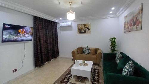 sala de estar con sofá verde y mesa en Appartement Hanna en Nassene Srhira
