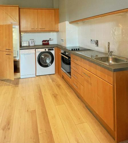 a kitchen with a sink and a washing machine at Biarritz Hotel in St Brelade