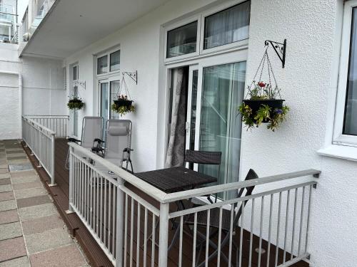 a porch with a chair and flowers on a house at Biarritz Hotel in St Brelade