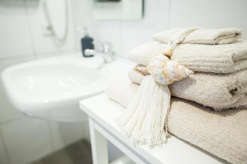 a pile of towels sitting on a counter in a bathroom at Hotel Strand26 an der Ostsee in Nienhagen
