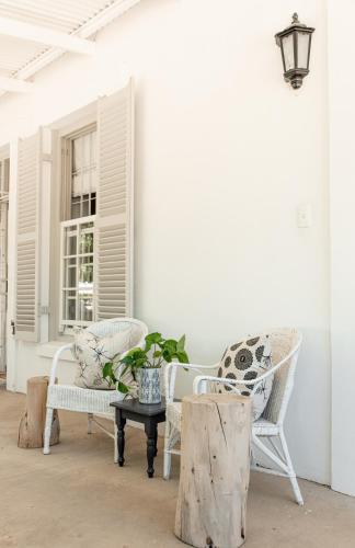 a porch with chairs and a table and a window at Cottage 1 at River Bend in Graaff-Reinet