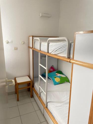 Cette chambre comprend 3 lits superposés et un tabouret. dans l'établissement Esterel Home, à Saint-Raphaël