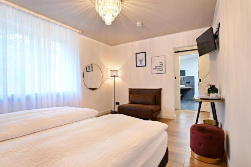 ein Schlafzimmer mit einem Bett, einem Stuhl und einem TV in der Unterkunft Hotel Zehnthof in Cochem