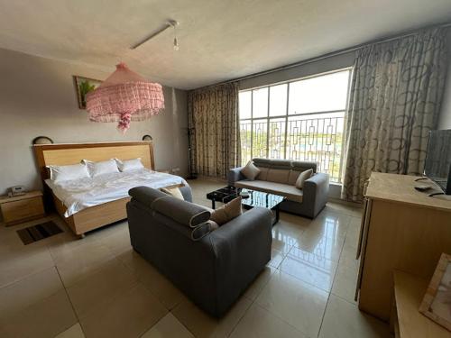 CROWN HOTEL INTERNATIONAL في ليلونغوي: غرفة نوم مع سرير وغرفة معيشة مع أريكة