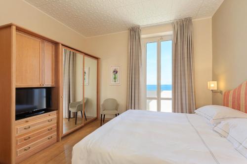 a hotel room with a bed and a large window at Grand Hotel Mediterranee in Alassio