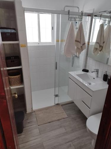 baño blanco con ducha y lavamanos en Agradable Chalet Familiar, en Torremolinos