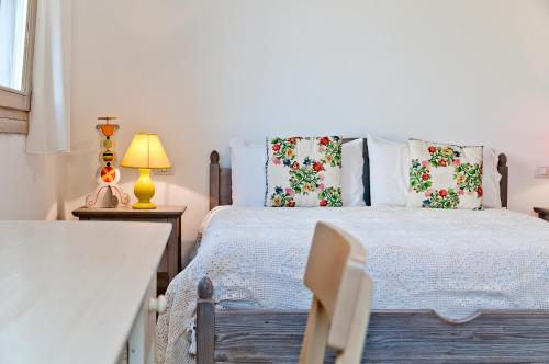 a bedroom with a bed with pillows and a lamp at Agriturismo Spirdo in Ruffano