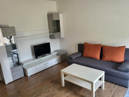 sala de estar con sofá y TV en Monteur Apartments, en Fohnsdorf