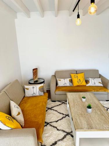 un salon avec deux canapés et une table dans l'établissement T5 lumineux - balcon - parking - linge inclus, à Vannes
