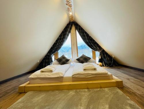 łóżko w pokoju z dużym oknem w obiekcie Luxury Houses & Apartments Zaliński w Zakopanem