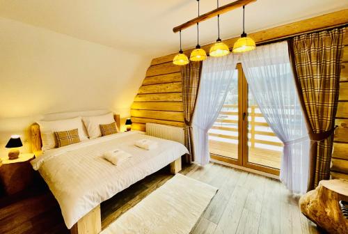 sypialnia z łóżkiem i dużym oknem w obiekcie Luxury Houses & Apartments Zaliński w Zakopanem