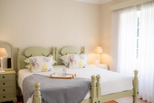 a bedroom with a green bed with a tray on it at Casa Da Piedade in São Vicente