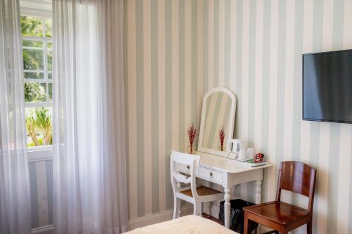 a bathroom with a white sink and a mirror at Casa Da Piedade in São Vicente