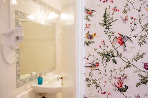 a bathroom with a floral wallpaper on the wall at Casa Da Piedade in São Vicente