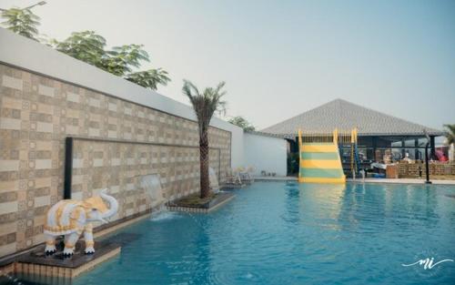 einem Pool mit einer Rutsche in der Mitte in der Unterkunft Muhurat Hotel and Resort, in Māndhar