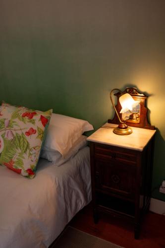a lamp on a night stand next to a bed at Casa Da Piedade in São Vicente