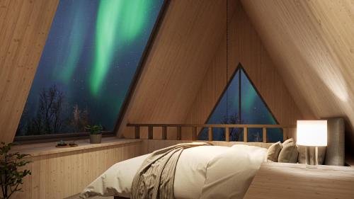 a bedroom with a bed and a window with the northern lights at Holmen Husky Lodge in Alta