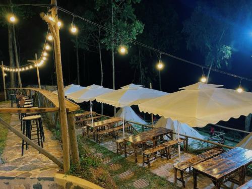 eine Gruppe von Tischen mit Sonnenschirmen in der Nacht in der Unterkunft Best View Đồng Văn in Ha Giang